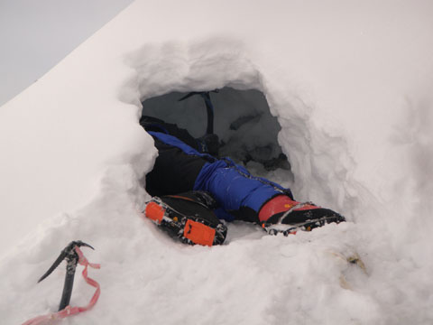 Сэнди Аллен (Sandy Allan) роет снежную пещеру для ночевки на склоне Нанга Парбат