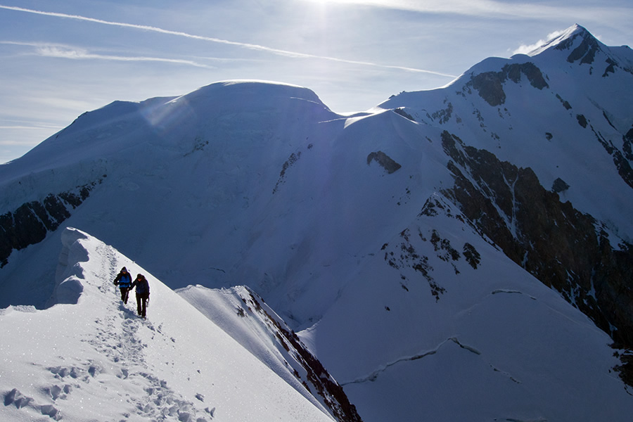 Пара альпинистов на гребне Bionassay на фоне вершины Монблан