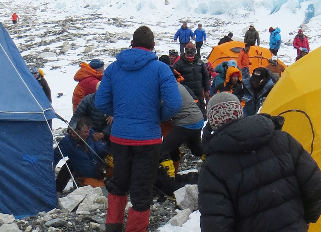 Ули Штек (внизу слева) на земле в лагере Camp2 на Эвересте. Фото после нападения Таши Шерпа. Симоне Моро можно увидеть убегающим, он в оранжевой куртке в верху слева. Фото MIchael Chambers