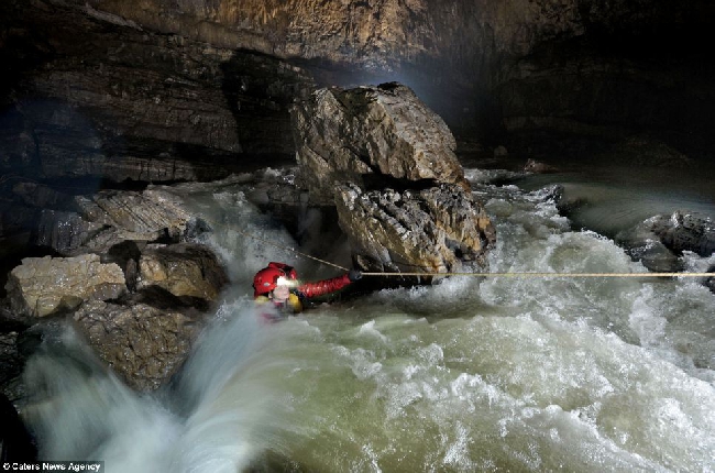 Американский спелеолог Erin Lynch пытается преодолеть бурный поток воды, являющейся основной рекой в ​​Quankou Dong. 