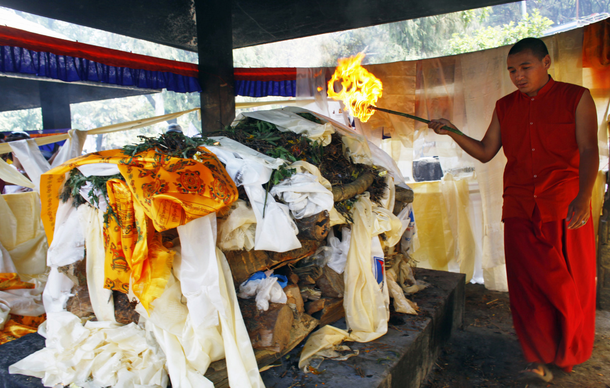 Буддийский монах проводит церемонию погребального сожжения тела погибшего шерпы Ang Kaji Sherpa