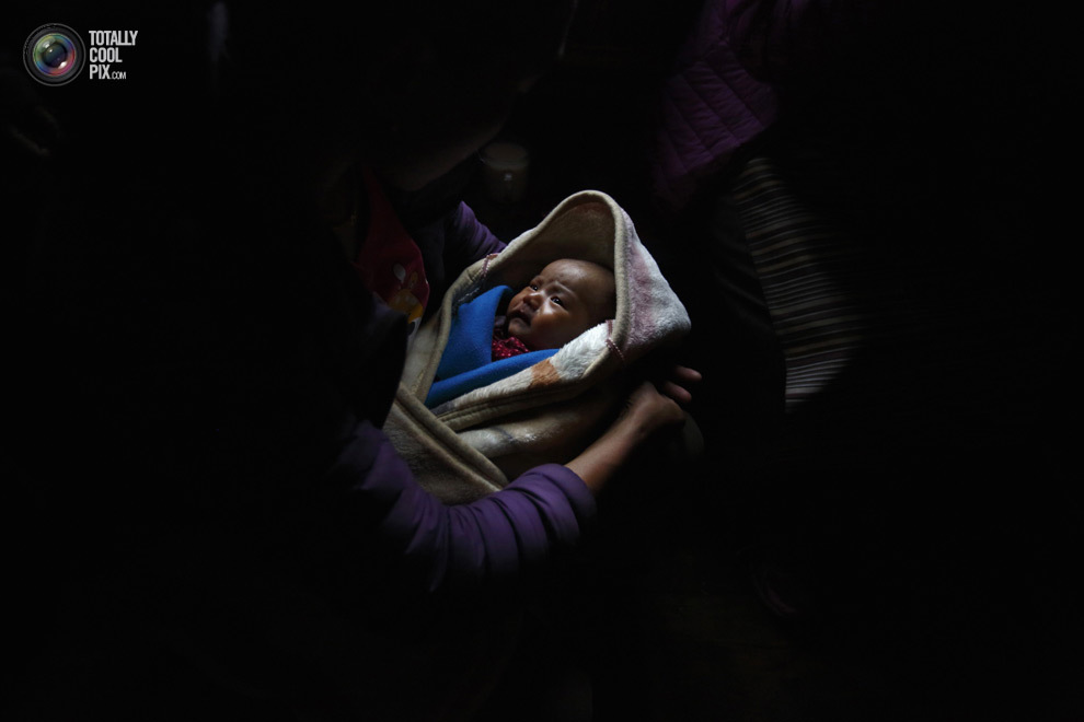 Женщина шерпа держит на руках своего ребёнка, отец которого погиб под лавиной, в районе Кхумбу, Непал. (NAVESH CHITRAKAR/REUTERS)