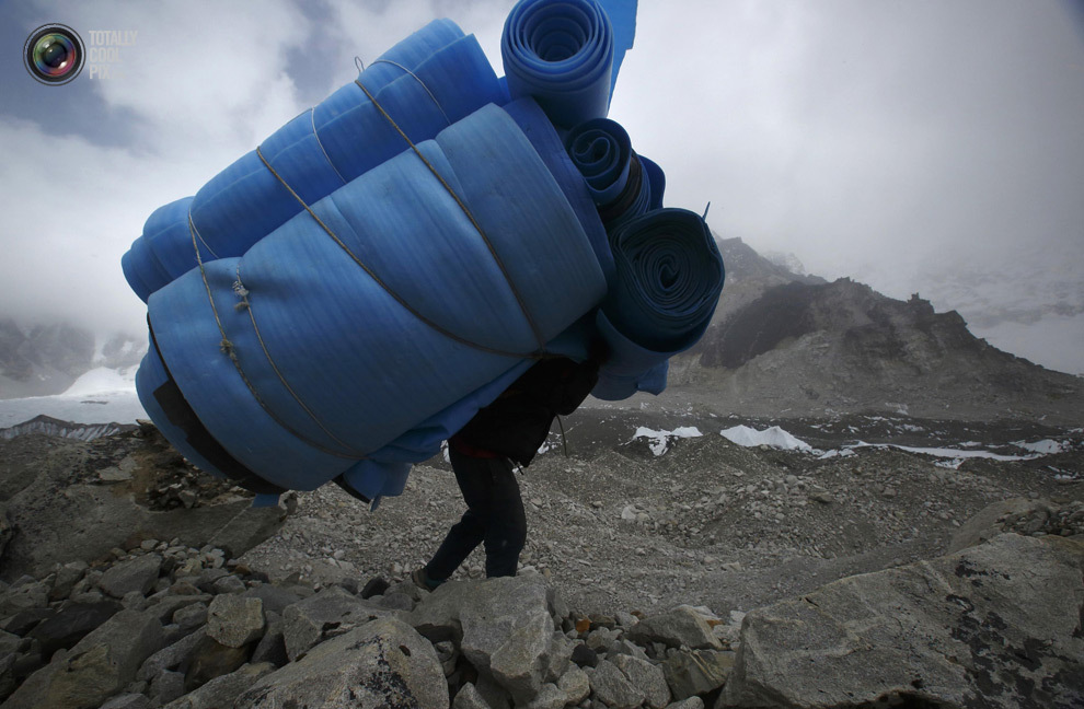 Носильщик уносит матрасы из базового лагеря Эвереста в районе Кхумбу, Непал. (NAVESH CHITRAKAR/REUTERS)
