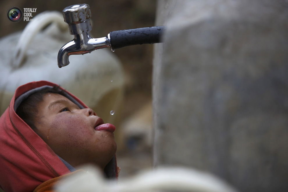 Мальчик ловит капли воды из-под крана в районе Кхумбу в Непале. (NAVESH CHITRAKAR/REUTERS)