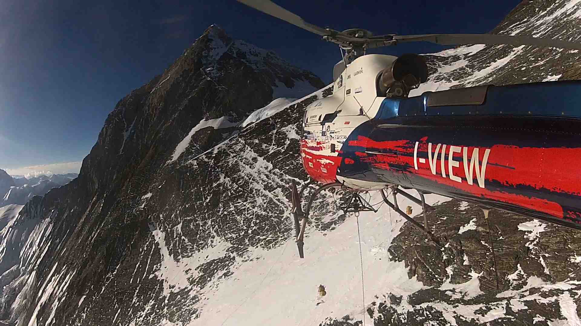 Спасательный вертолет Маурицио Фолини (Maurizio Folini) с пострадавшим альпинистом в носилках на тросе. Эверест. май 2013 года