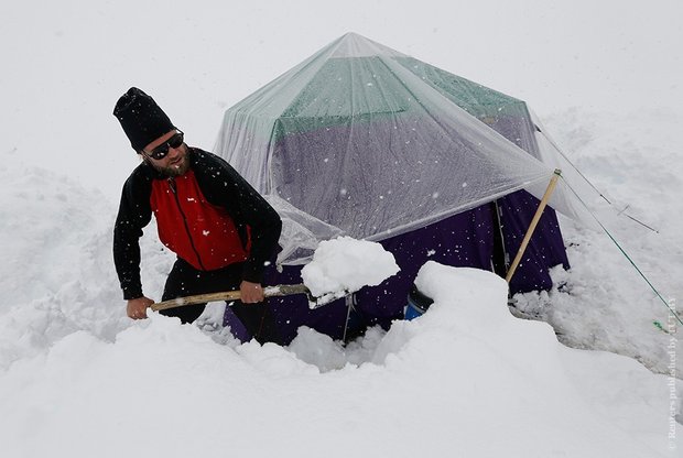 Альпинист из Германии расчищает походную кухню от снега. Фото: Reuters / Wolfgang Rattay