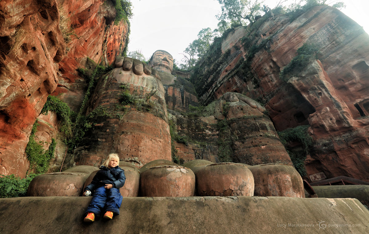 «Девочка-с-пальчик» у ступни легендарного Лэшаньского Будды, высочайшей скульптуры (70 метров), высеченной в скальном массиве 1000 лет назад. Китай (Амелии 5 лет)