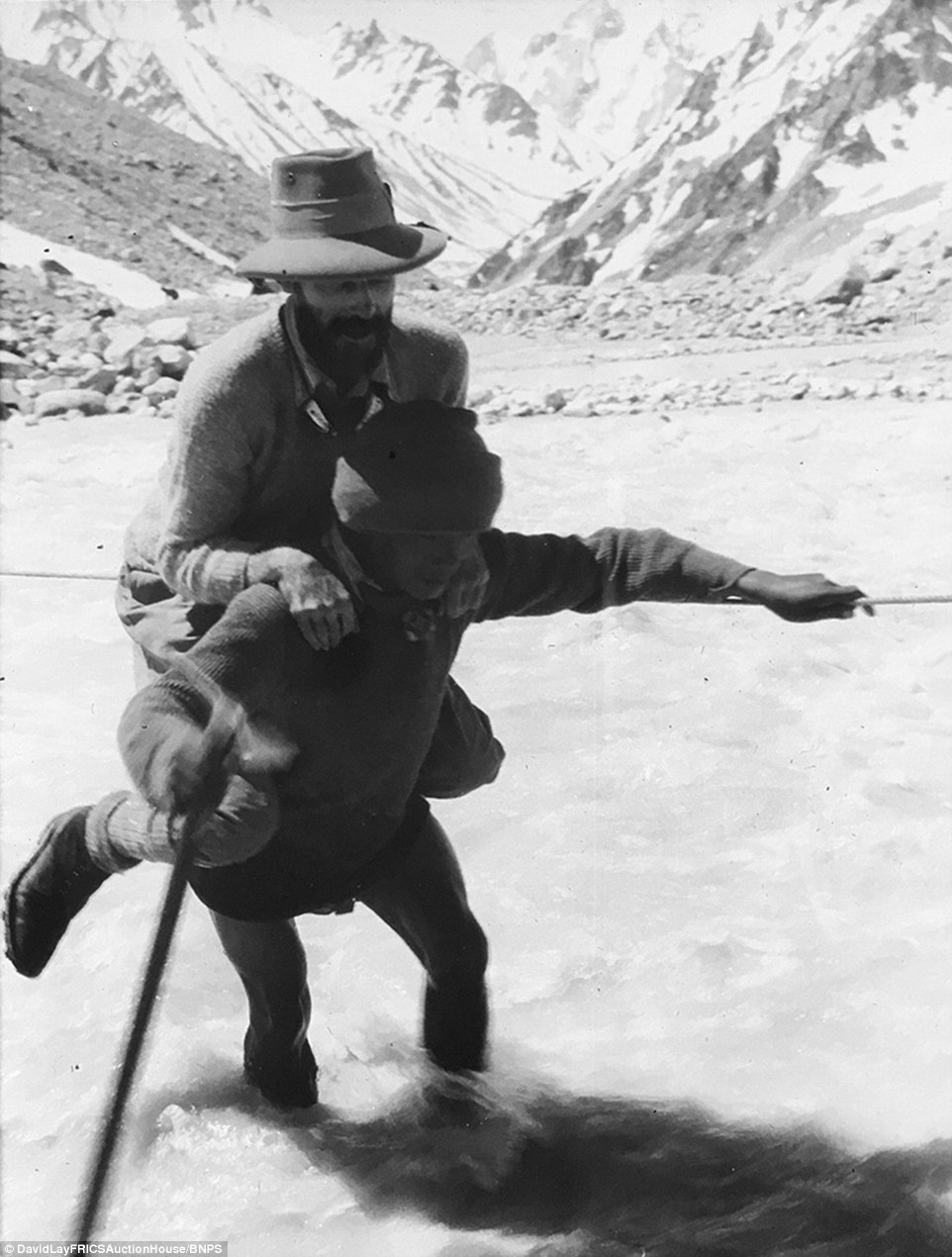 В брод: шерпа несет на себе альпиниста. Британская экспедиция на вершину гималайской горы Камет (Mount Kamet 7756 м). 1931 год. Фото Frank Smythe