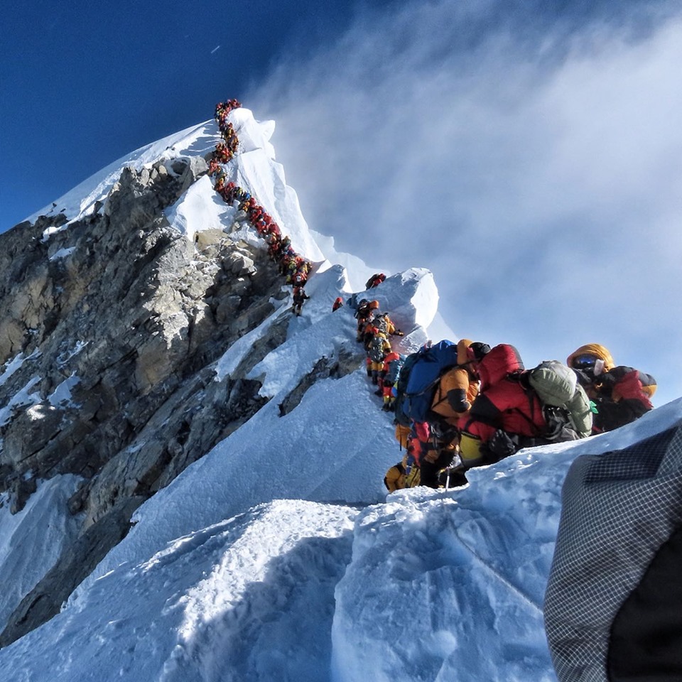 Это фото было сделано непальским альпинистом Нирмалом Пуржа (Nirmal Purja) 22 мая 2019 года у ступени Хиллари - последнего сложного участка перед вершиной мира - горой Эверест.<br>По словам Нирмала в этот день на вершину Эвереста поднимались около 320 альпинистов.