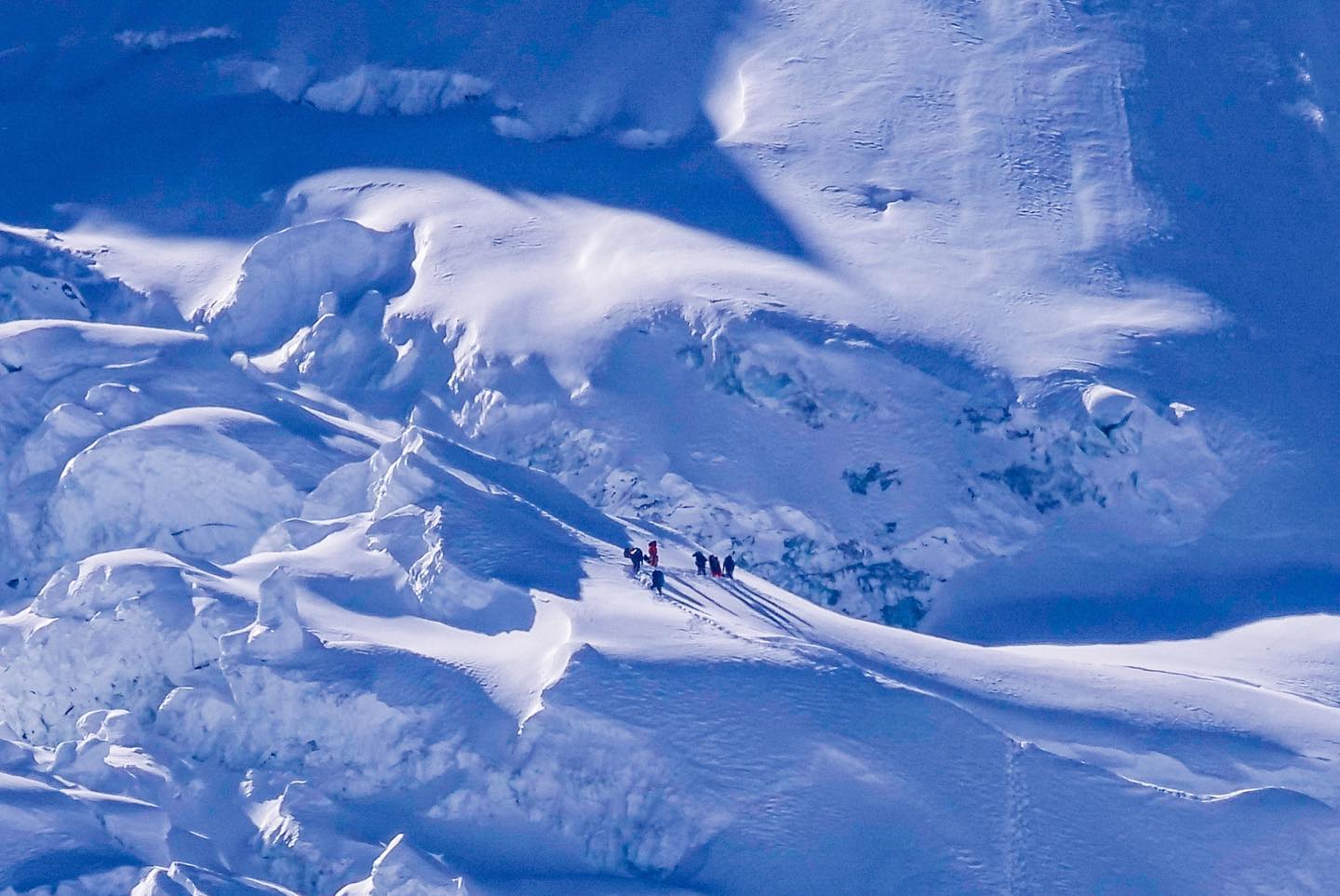 крохотная нить "муравьёв-альпинистов", пытающаяся взобраться на огромную стену заснеженной горы. Фото Alex Txikon