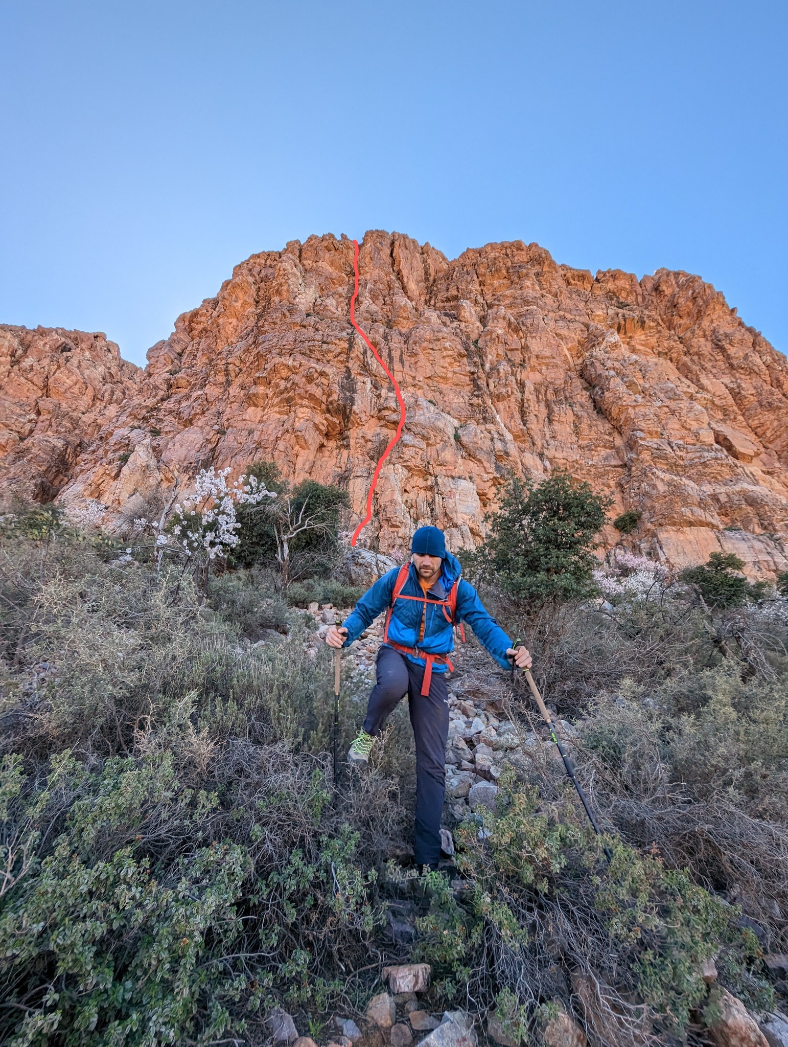 Джессі Дафтон (Jesse Dufton) на фоні нового маршруту «Eye Disappear» (4b, 100 метрів, 3 мотузки) на скелях Heavy Rock в Марокканських Антиатлаських горах. Фото Jesse Dufton