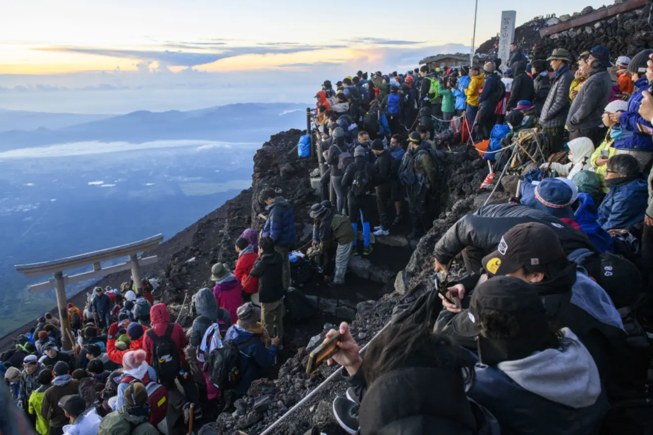 На фотографії, зробленій у серпні 2023 року, видно вершину гори Фудзі , переповнену альпіністами, які зібралися, щоб побачити схід сонця. Фото префектури Яманасі, Кіодо